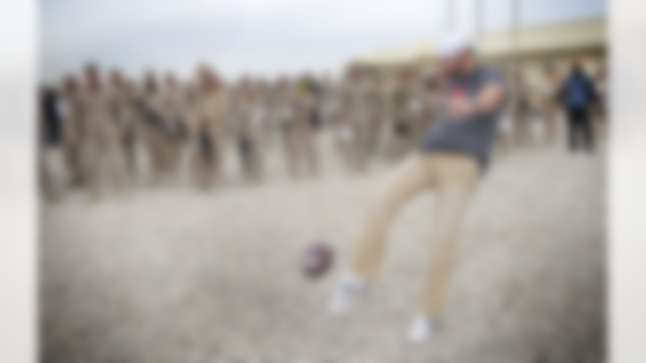 On the second day of his USO/NFL tour to the Middle East, Brandon Fields of the Miami Dolphins practices punting a football to a soldier as fellow troops watch on March 5, 2014. Fields is joined by Pierre Garcon of the Washington Redskins and Jimmy Graham of the New Orleans Saints, who are in the region to help the USO make �Every Moment Count� with troops. (USO Photo by Dave Gatley)