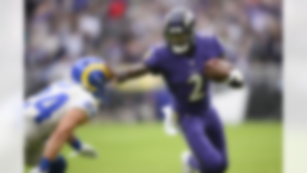 Baltimore Ravens quarterback Tyler Huntley (2) applies a stiff arm on Los Angeles Rams free safety Taylor Rapp (24) while scrambling for yardage during the first half of an NFL football game, Sunday, Jan. 2, 2022, in Baltimore.