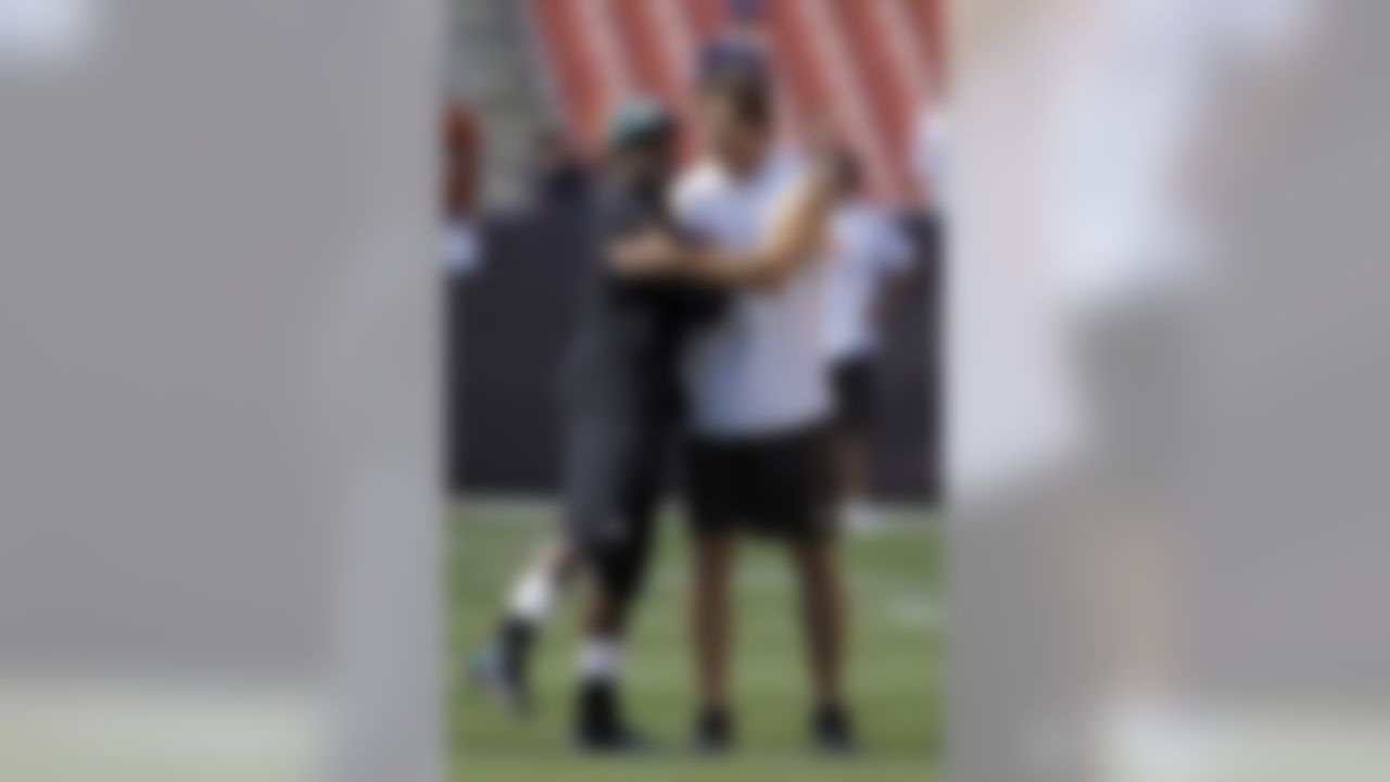 Philadelphia Eagles quarterback Michael Vick, left, hugs Cleveland Browns linebacker Scott Fujita before an NFL football game Sunday, Sept. 9, 2012, in Cleveland. (AP Photo/Mark Duncan)