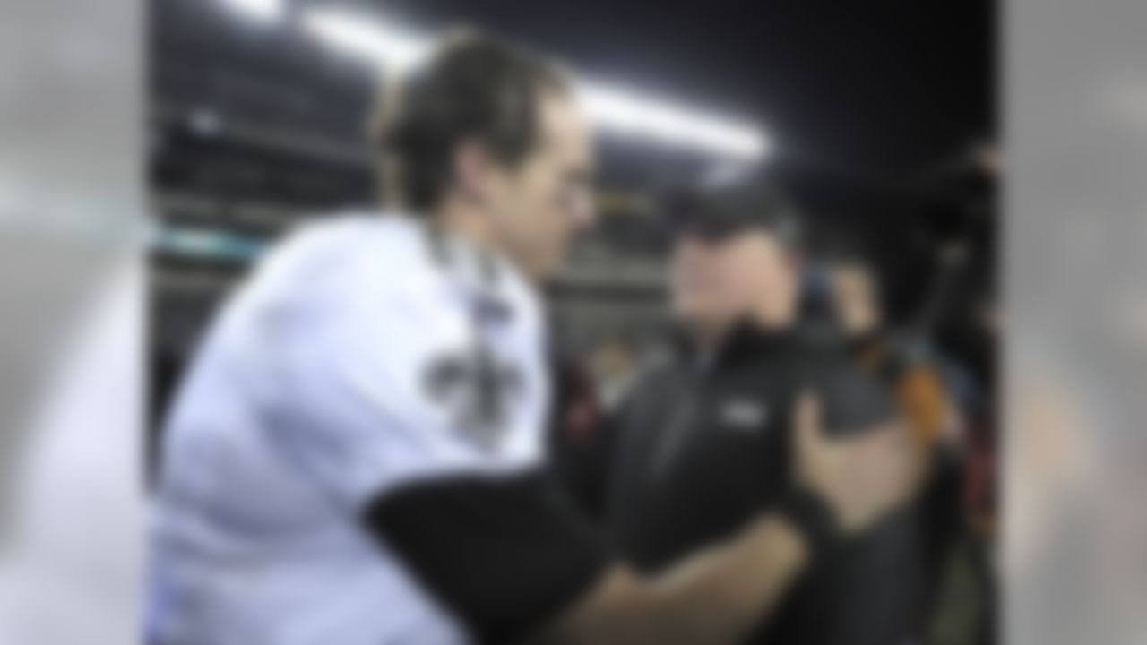 Philadelphia Eagles head coach Chip Kelly, right, meets with New Orleans Saints' Drew Brees after an NFL wild-card playoff football game, Saturday, Jan. 4, 2014, in Philadelphia. New Orleans won 26-24. (AP Photo/Michael Perez)