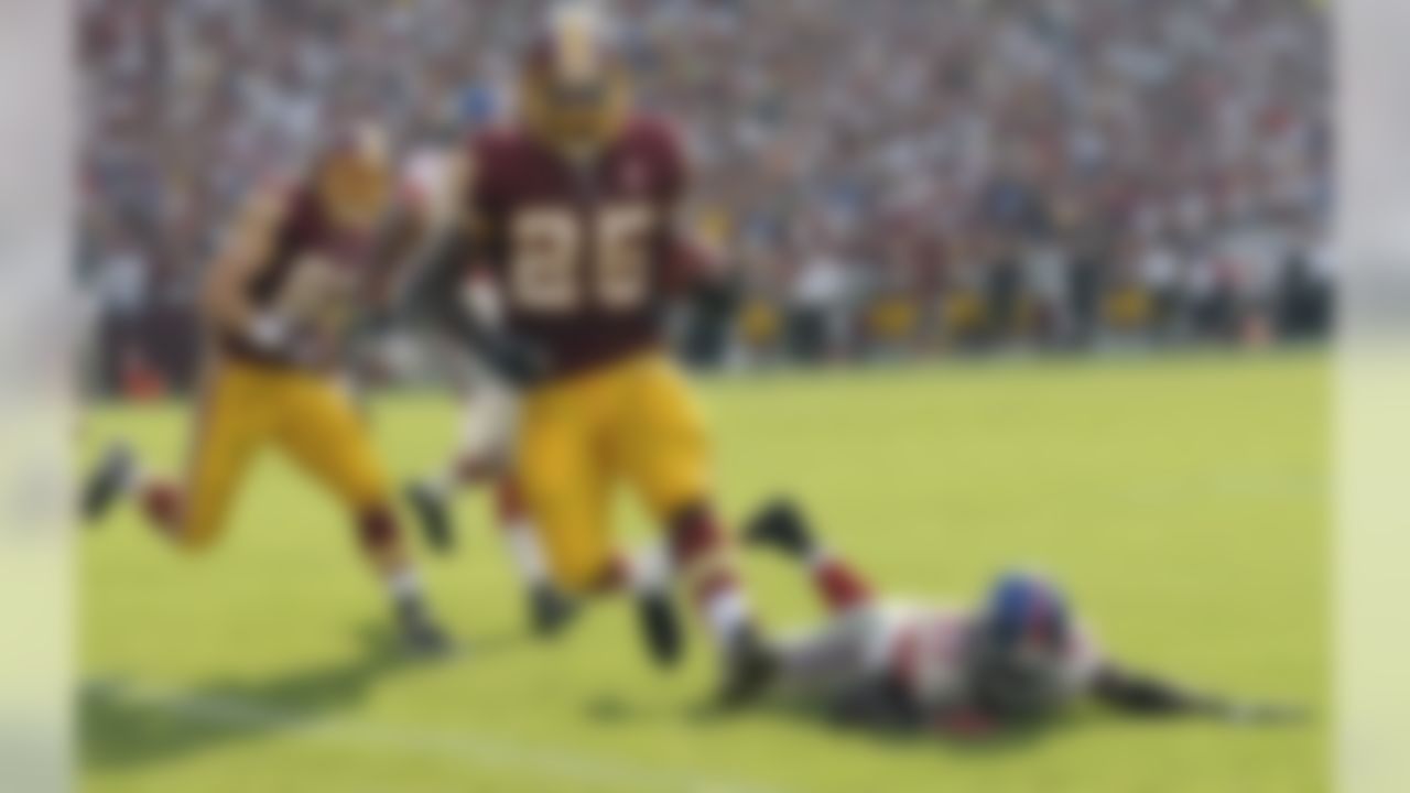 Washington Redskins running back Tim Hightower carries the ball into the end zone for a touchdown leaving New York Giants linebacker Greg Jones lying on the ground during the first half of an NFL football game in Landover, Md., on Sunday, Sept. 11, 2011.  (AP Photo/Susan Walsh)