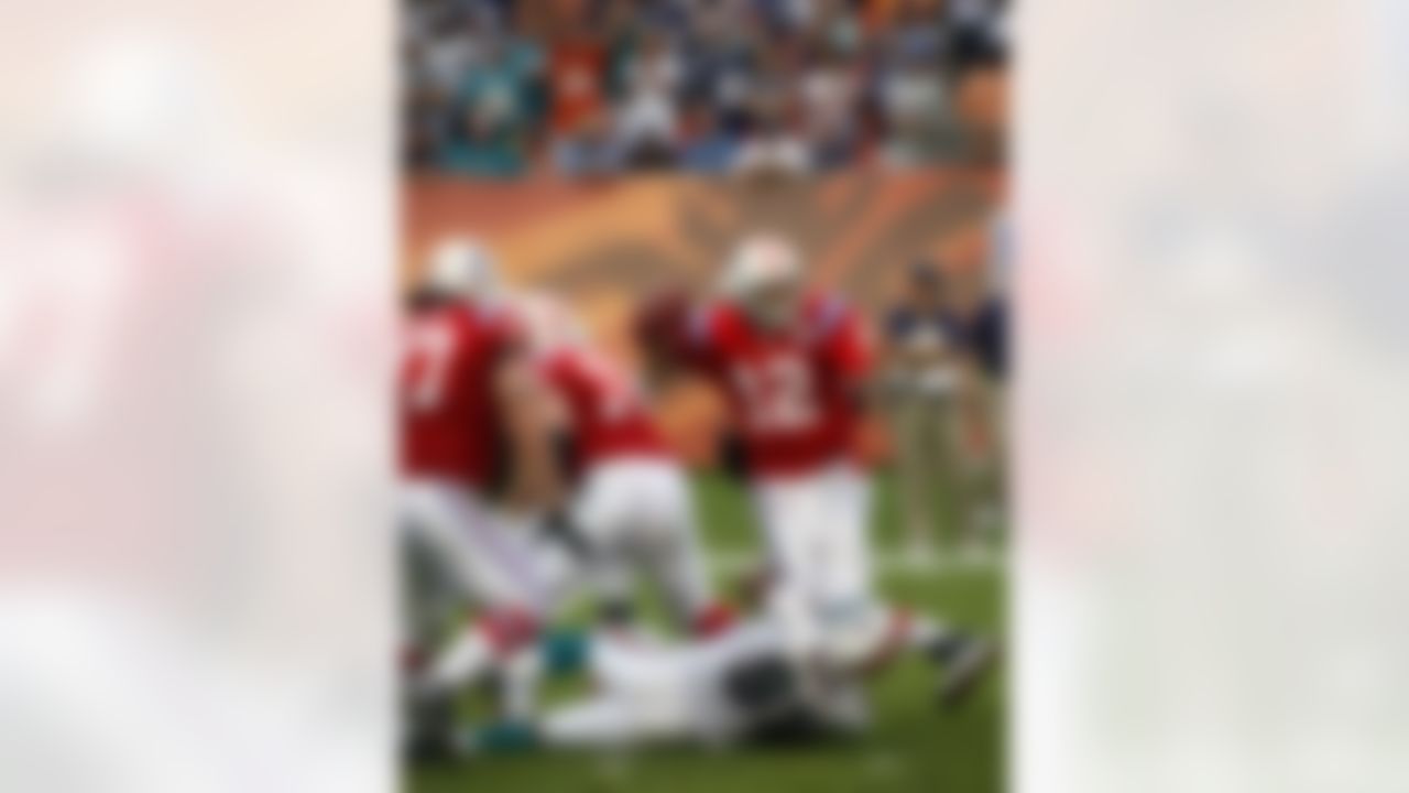 New England Patriots quarterback Tom Brady (12) is taken down by Miami Dolphins linebacker Cameron Wake during the fourth quarter of an NFL football game Sunday, Dec. 6, 2009 in Miami. Brady released the ball and it was intercepted by Miami Dolphins linebacker Channing Crowder] (not shown) to allow the Dolphins to win 22-21. (AP Photo/Wilfredo Lee)