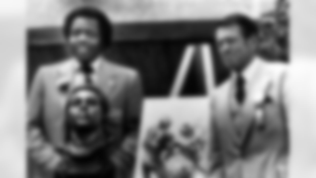 Former Los Angeles Rams defensive end Deacon Jones, left, poses with his bust and a drawing of him in action after enshrinement in the Pro Football Hall of Fame in Canton, Ohio, Aug. 2, 1980. Jones was presented for induction by former Rams head coach George Allen, eight. (AP Photo)