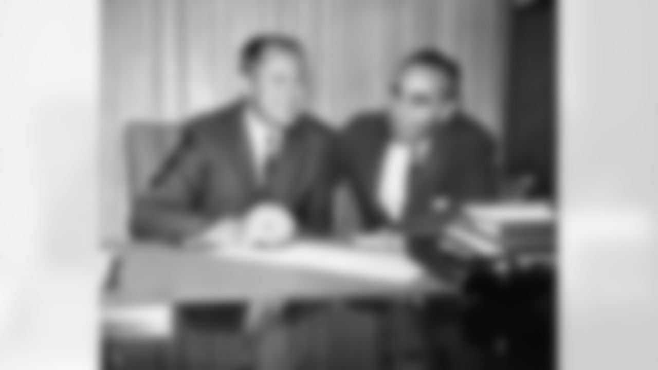 Jack Christiansen, left, head coach for the last eleven 49er games, holds a pen over his 1964 contract as 49er President Vic Morabito looks on, Dec. 23, 1963 in San Francisco. The contract was signed in the club office, giving Christiansen a full season at the helm. He replaced Red Hickey, who resigned after a poor showing by the team during early games of this season. (AP Photo/Robert W. Klein)