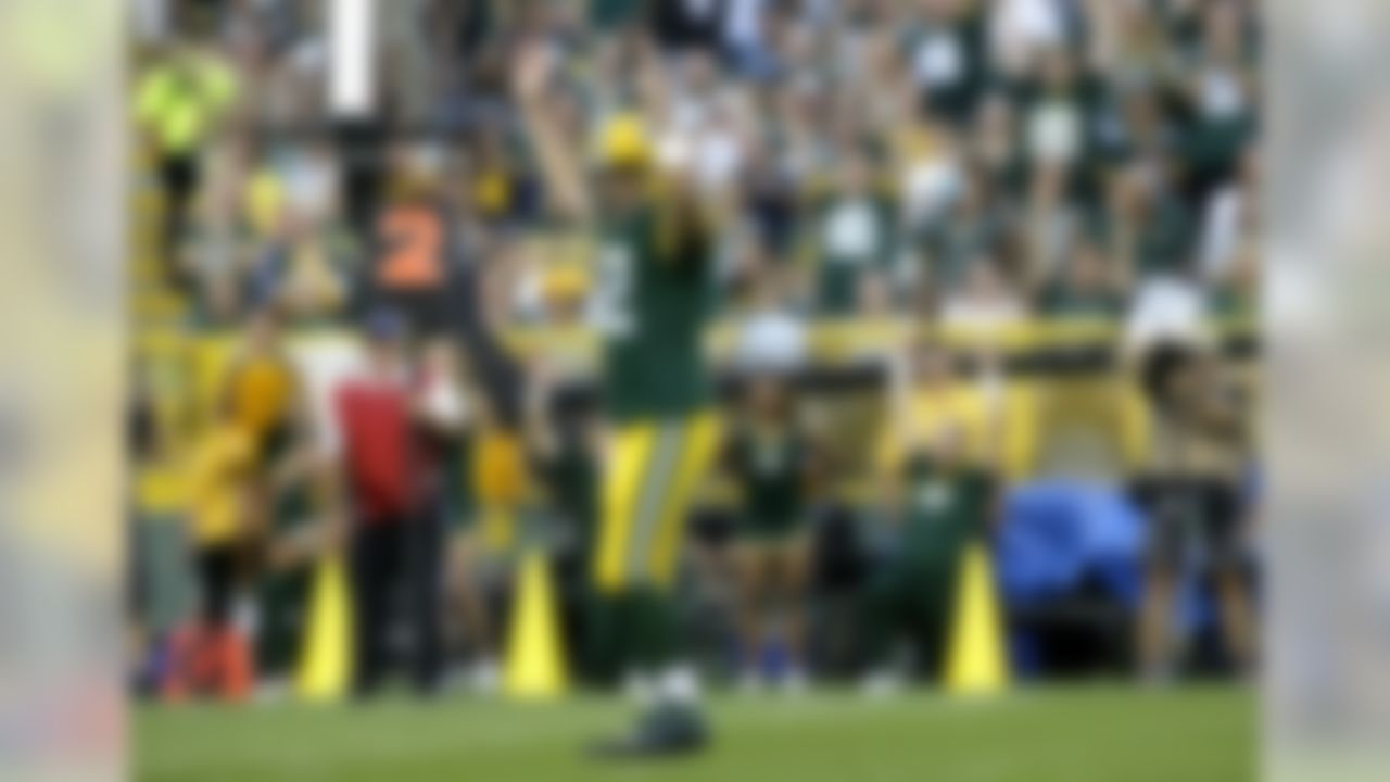 Green Bay Packers quarterback Aaron Rodgers (12) signals a touchdown after the Packers scored against the Oakland Raiders during the first quarter of an NFL preseason football game Friday, Aug. 22, 2014, in Green Bay, Wis. (AP Photo/Morry Gash)