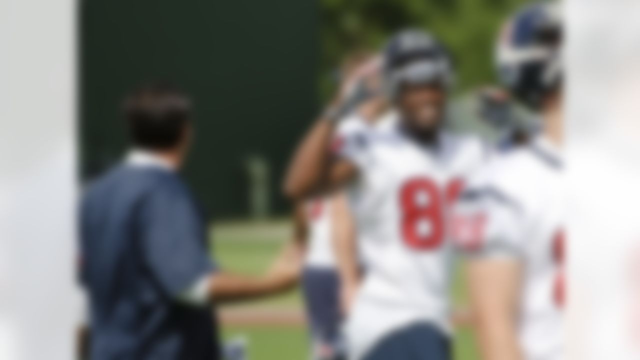 Houston Texans receiver Andre Johnson (80) smiles at coach Brian Pariani, left, during an NFL football mini camp, Thursday, May 20, 2010, in Houston. Johnson is in a contract dispute with the Texans and missed the opening three voluntary practices. (AP Photo/Dave Einsel)
