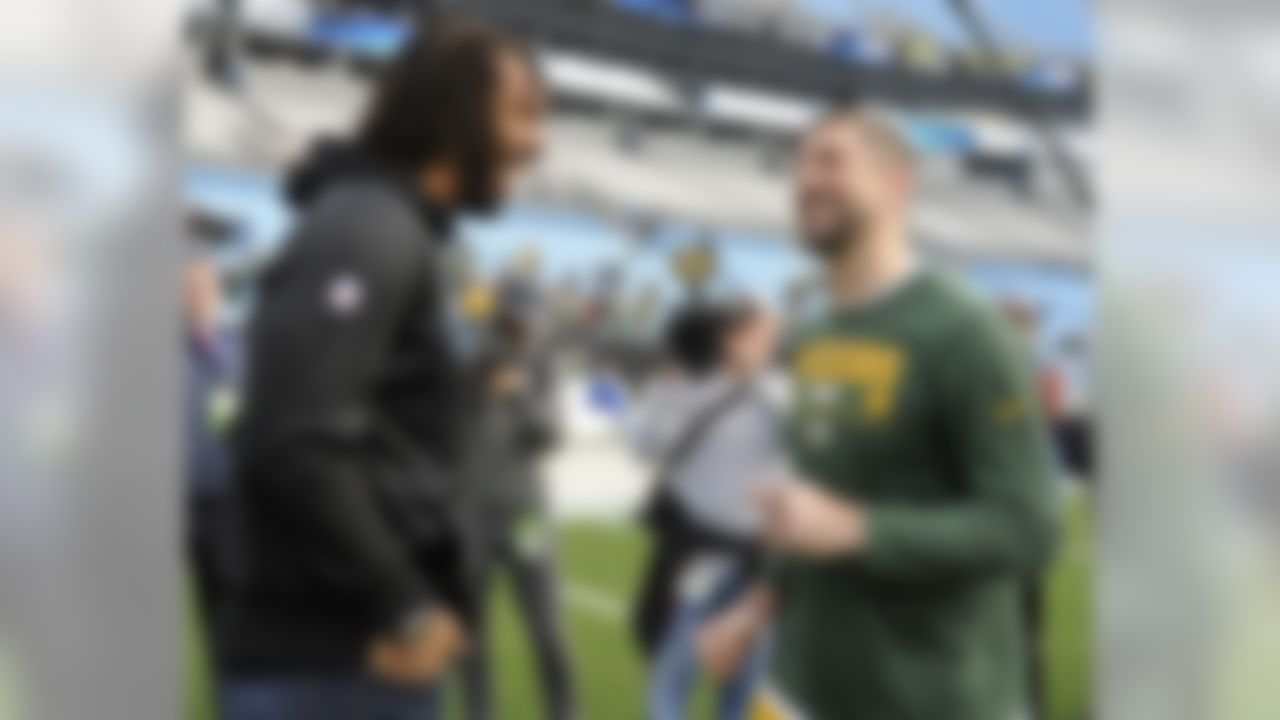 Green Bay Packers' Aaron Rodgers, right, talks with former teammate Carolina Panthers' Julius Peppers, left, before an NFL football game in Charlotte, N.C., Sunday, Dec. 17, 2017. (AP Photo/Mike McCarn)