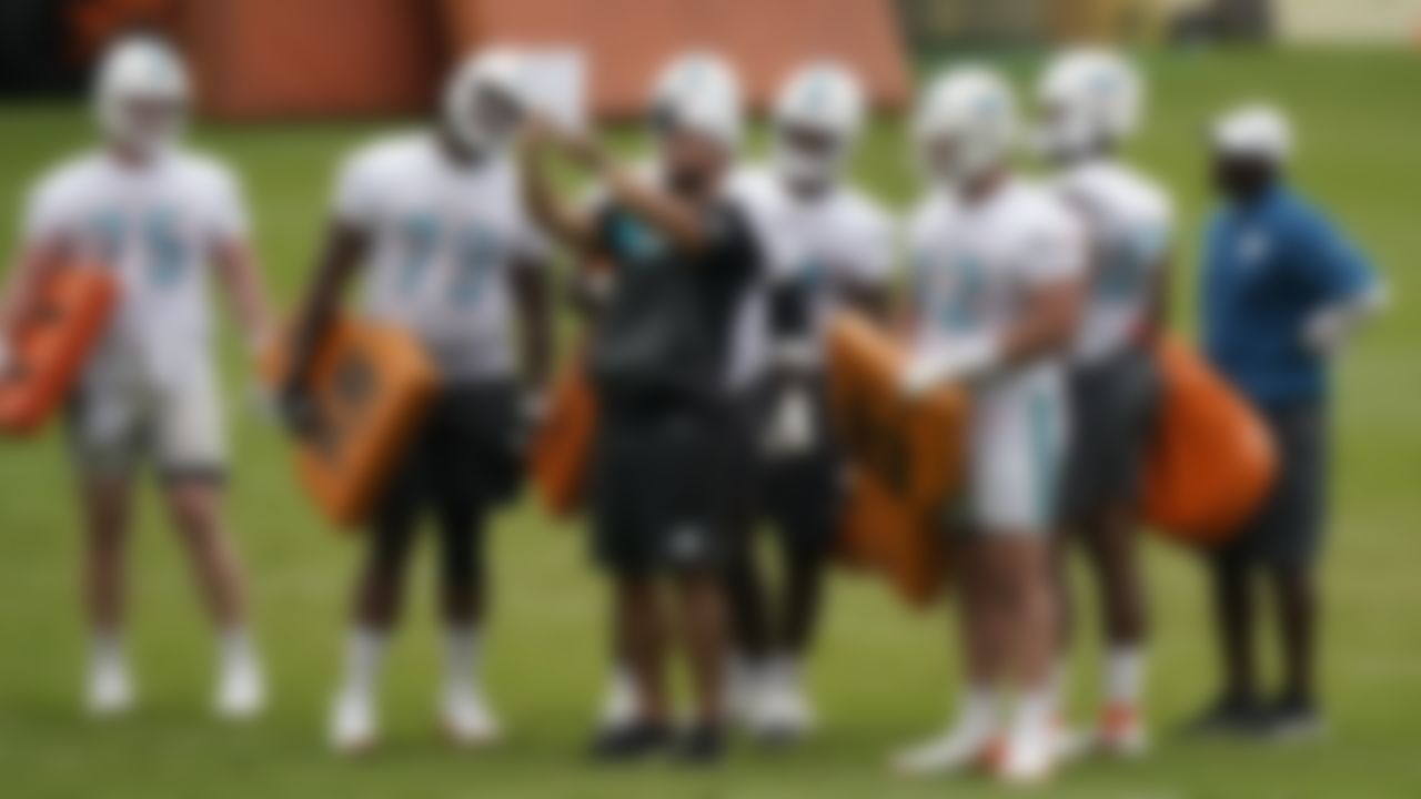 Miami Dolphins assistant offensive line coach Shawn Flaherty, center, talks with players during a drill as head coach Brian Flores, far right, looks on during a mandatory minicamp at the NFL football team's training camp, Wednesday, June 16, 2021, in Davie, Fla.