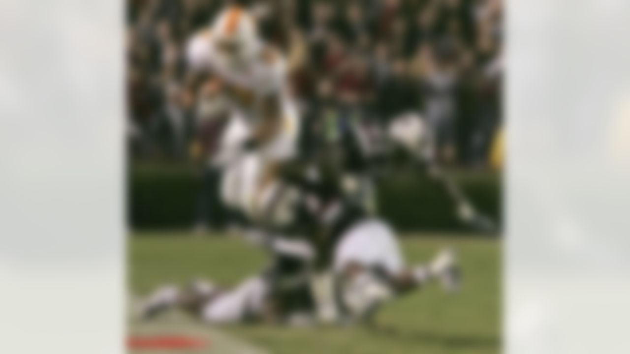 Tennessee's Arian Foster (27) dives for a first down as South Carolina's Akeem Auguste (3), Darian Stewart (24) and Stoney Woodson (36) try to stop him during the first half of an NCAA college football game Saturday, Nov. 1, 2008, at Williams-Brice Stadium in Columbia, S.C. (AP Photo/Mary Ann Chastain)