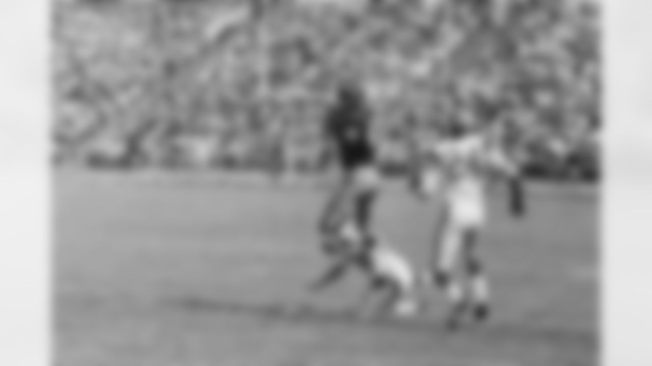 Charley Taylor of the Washington Redskins takes a 14-yard pass on his own 30-yard line and runs 70 yards more for a touchdown in the first quarter of their game with the Los Angeles Rams at the Los Angeles Coliseum on Oct. 22, 1967. Trying for the tackle are Rams: Claude Crabb (on ground) and Clarence Williams, defensive Backs. (Associated Press)