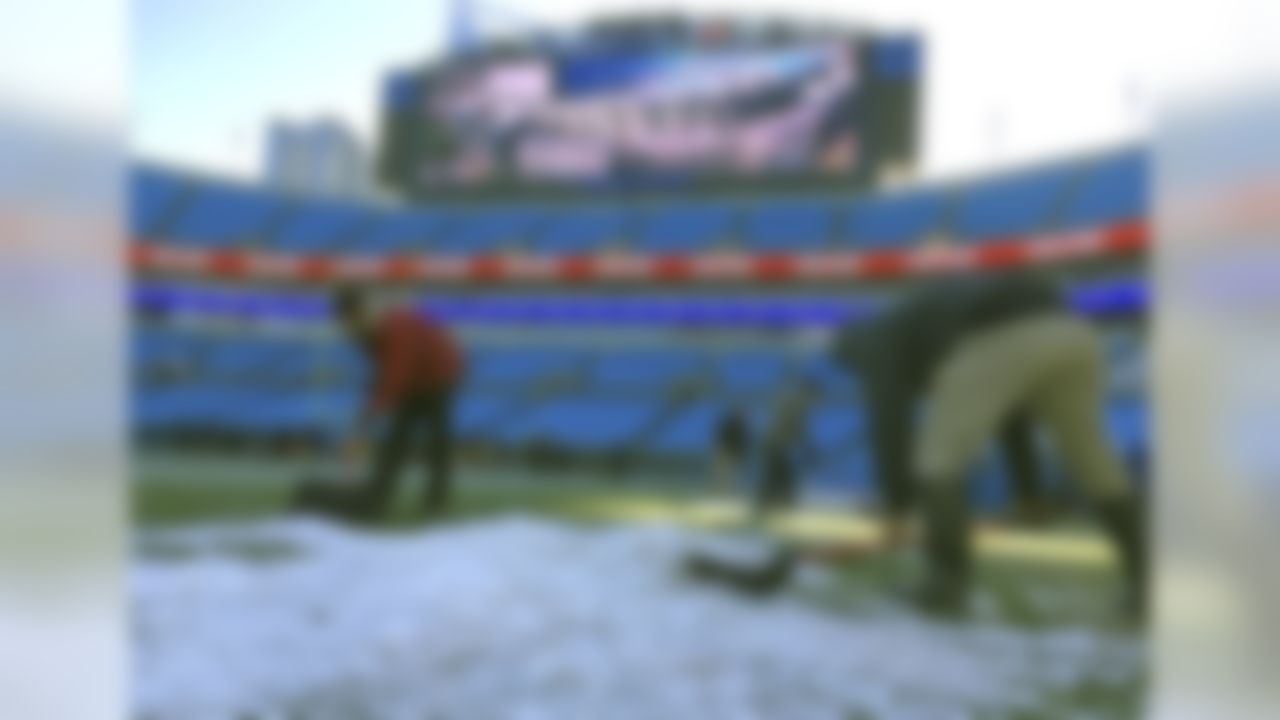 Members of the grounds crew remove ice from the sidelines before an NFL football game between the Carolina Panthers and the Minnesota Vikings in Charlotte, N.C., Sunday, Dec. 10, 2017. (AP Photo/Chuck Burton)