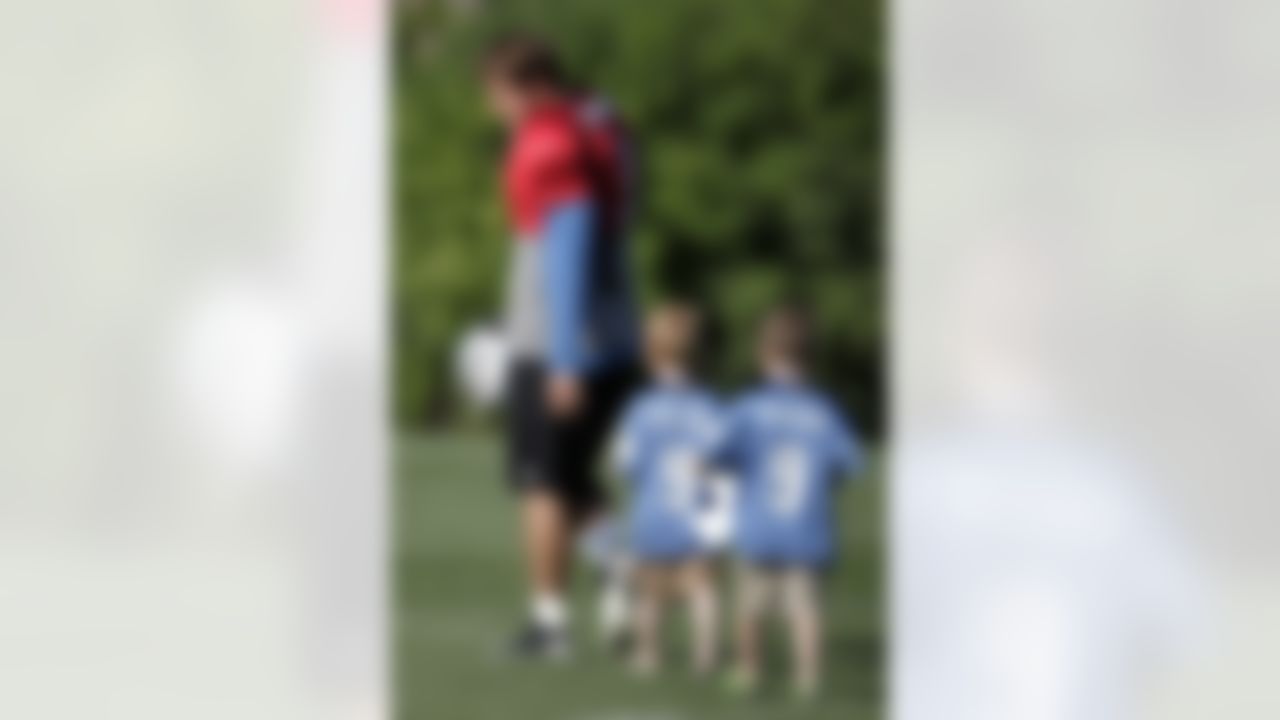 Detroit Lions quarterback Matthew Stafford, left, is followed onto the field by 5-year-old twins Cooper and Carter Aquilina before the start of the Lions' NFL football training camp Sunday, July 29, 2012, in Allen Park, Mich. (AP Photo/Duane Burleson)
