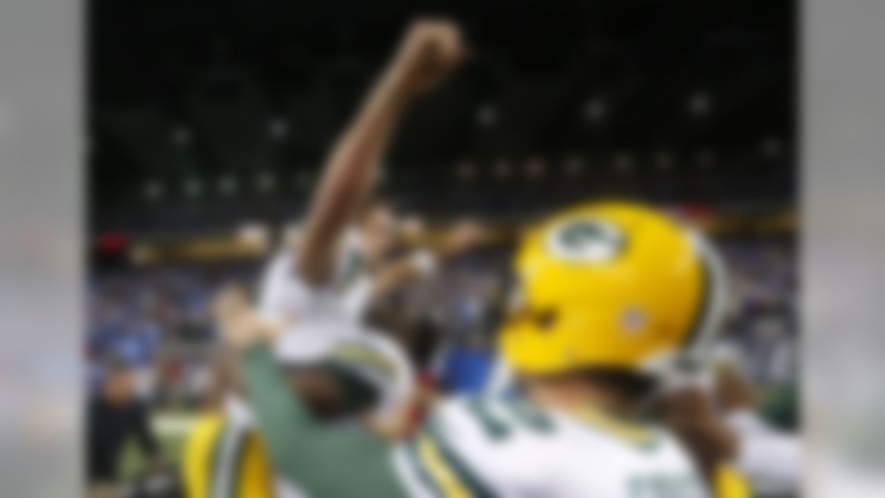 Green Bay Packers quarterback Aaron Rodgers raises his arms after throwing a 61-yard pass for a touchdown during the second half of an NFL football game against the Detroit Lions, Thursday, Dec. 3, 2015, in Detroit. (AP Photo/Paul Sancya)