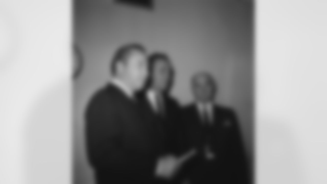 Detroit Lions President William Clay Ford, left, announces that head coach George Wilson, center, had been given an extended coaching contract for an indefinite period, Dec. 21, 1964. Lions' general manager Edwin Anderson is at right. At the same time, Ford revealed that joint decision was made by the three, relieving all the Lions assistant coaches of their duties, with Wilson free to form his new staff for the 1965 season. (AP Photo/Alvan Quinn)