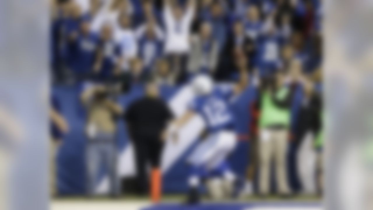 Indianapolis Colts quarterback Andrew Luck (12) spike the ball as he celebrates his touchdown during the second half of an NFL football game against the Denver Broncos, Sunday, Oct. 20, 2013, in Indianapolis. (AP Photo/Michael Conroy)