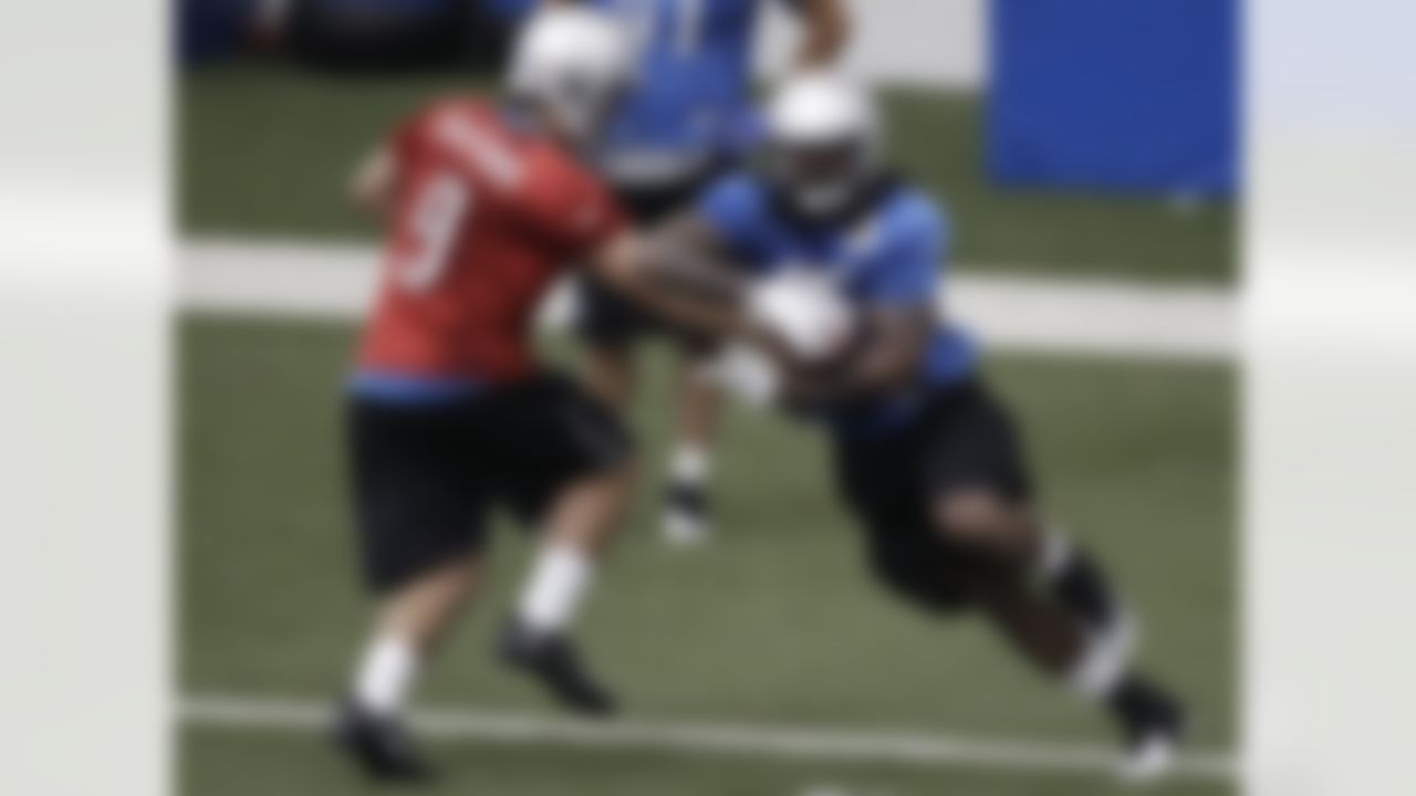 Detroit Lions quarterback Matthew Stafford (9) hands off to running back Mikel Leshoure during NFL football training camp at the team's indoor practice facility in Allen Park, Mich., Friday, July 29, 2011. (AP Photo/Paul Sancya)