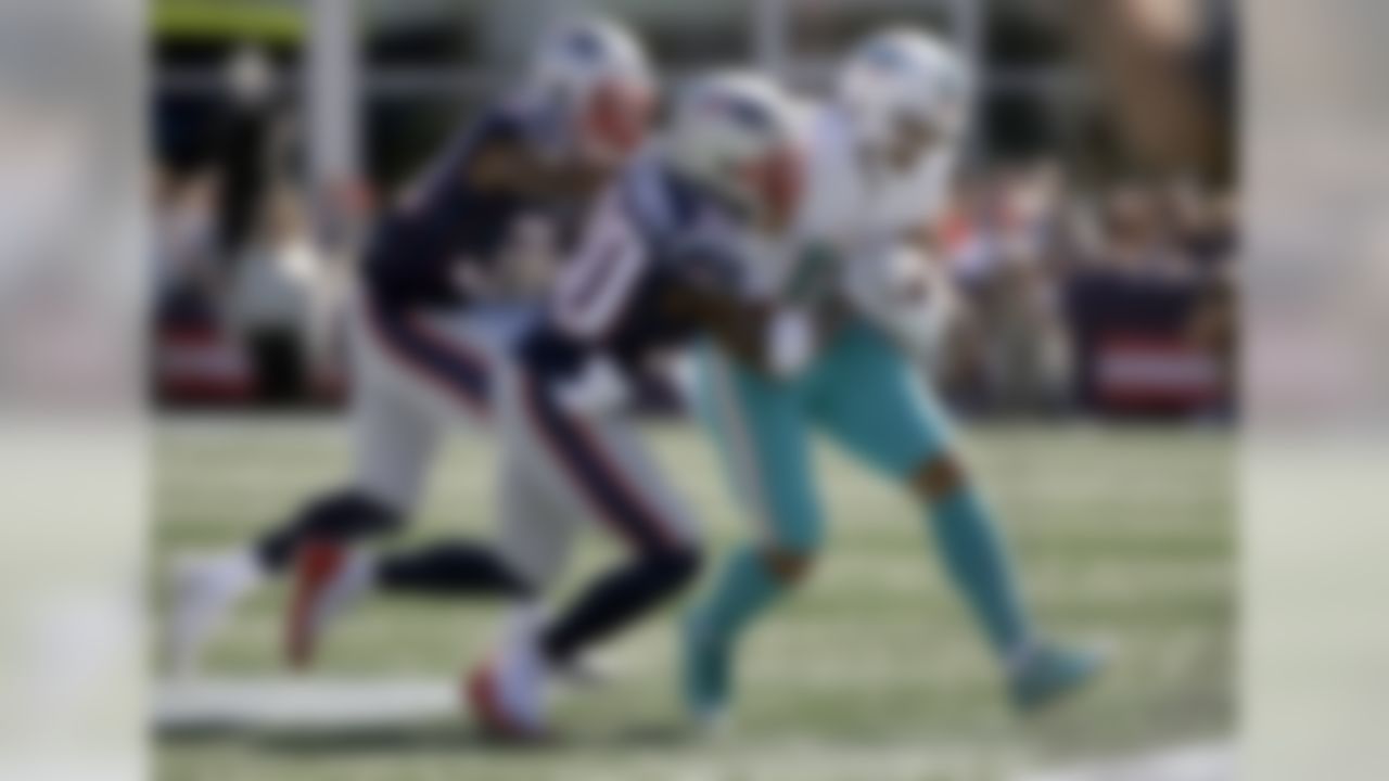 New England Patriots defensive backs Jonathan Jones, left, and and Jason McCourty (30) ride Miami Dolphins wide receiver Albert Wilson (15) out of bounds during the first half of an NFL football game, Sunday, Sept. 30, 2018, in Foxborough, Mass. (AP Photo/Steven Senne)