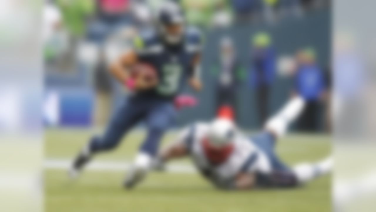 Seattle Seahawks quarterback Russell Wilson scrambles with New England Patriots'  Vince Wilfork on the ground in the first half of an NFL football game, Sunday, Oct. 14, 2012, in Seattle.  (AP Photo/John Froschauer)