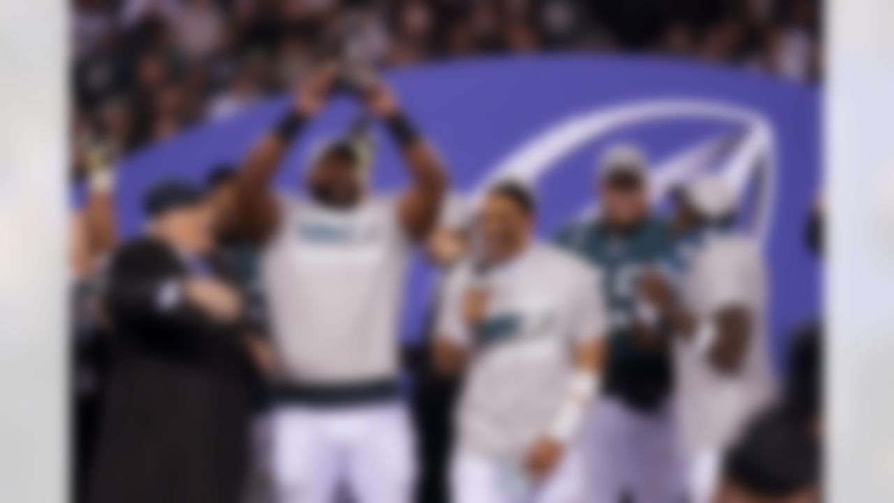 Terry Bradshaw, left, reacts as Philadelphia Eagles defensive tackle Fletcher Cox, second from left, hoists the George Halas Trophy as quarterback Jalen Hurts, center, holds a microphone after the NFC Championship NFL football game between the Philadelphia Eagles and the San Francisco 49ers on Sunday, Jan. 29, 2023, in Philadelphia. The Eagles won 31-7.