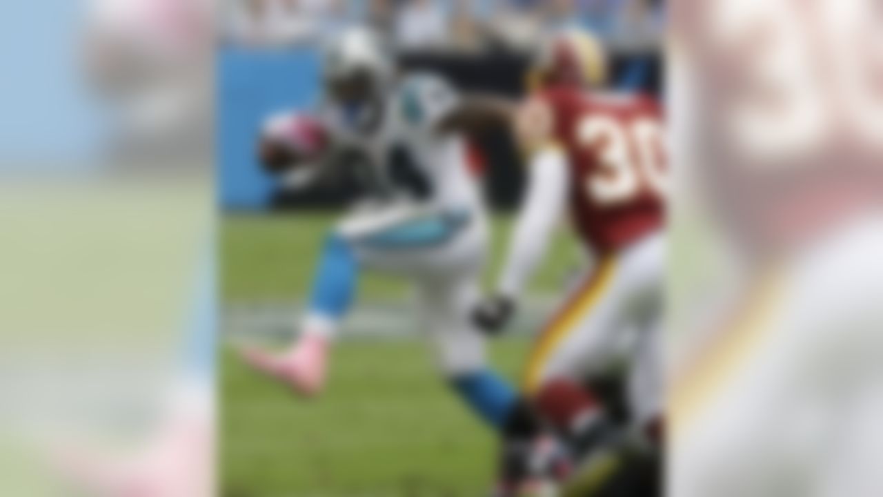 Carolina Panthers' DeAngelo Williams (34) runs past Washington Redskins' LaRon Landry (30) in the first half of an NFL football game in Charlotte, N.C., Sunday, Oct. 11, 2009.  (AP Photo/Chuck Burton)