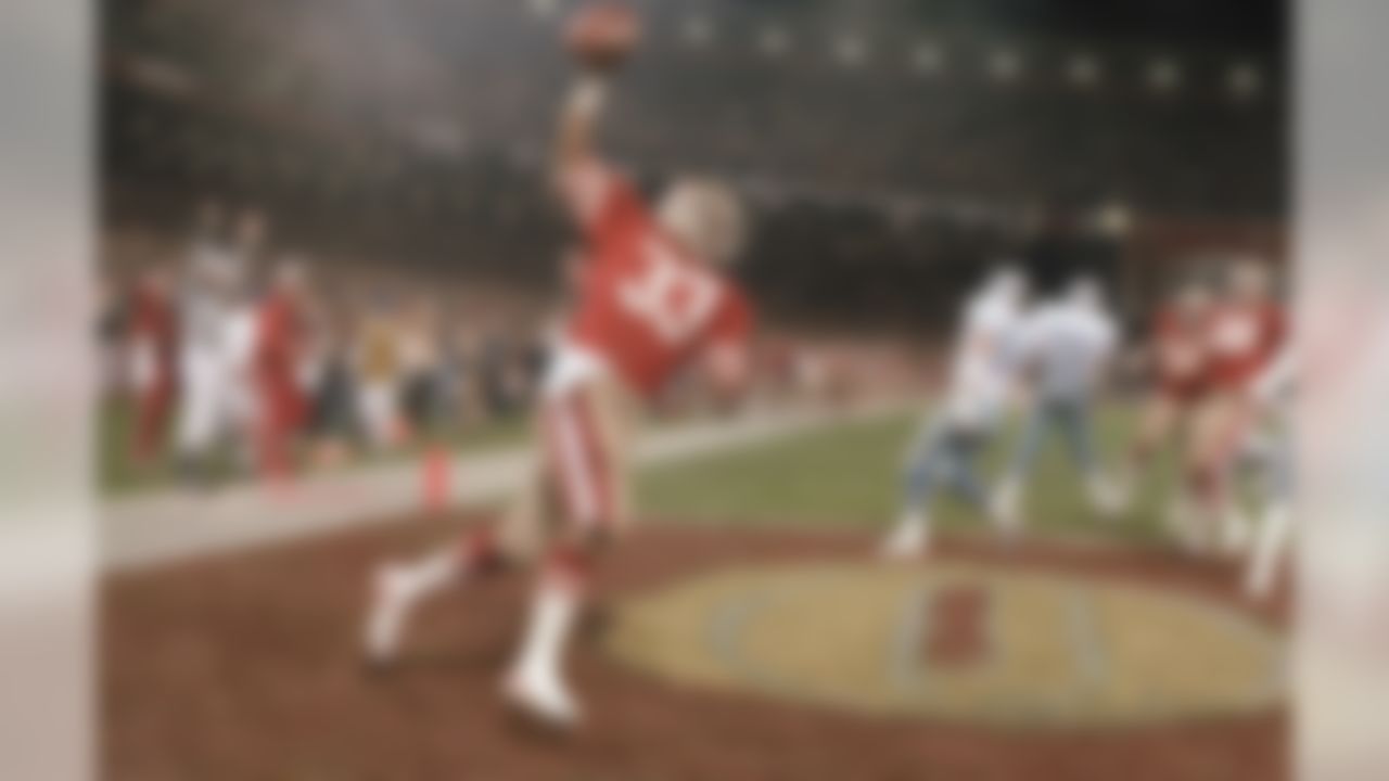 Roger Craig #33 runs with the ball push in the air after scoring a touchdown early in the first quarter against the Dallas cowboys in Candlestick Park, San Francisco on Monday, Dec. 20, 1983. Craig second two touchdowns in the 49ers 42-17 win that gave them the NGC west title. (AP Photo/Eric Risberg)
