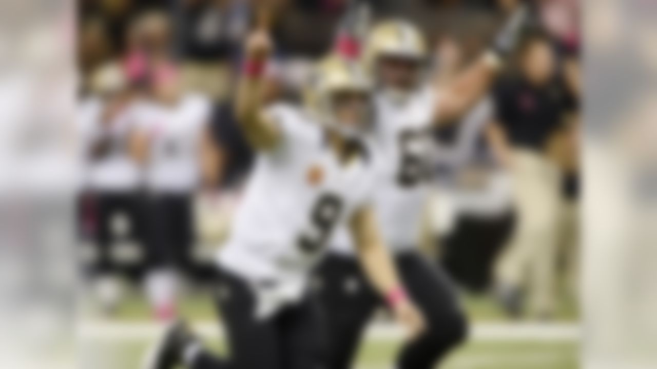 Drew Brees reacts with center Brian De La Puente (60) after throwing a touchdown pass in the first half of an NFL football game at the Mercedes-Benz Superdome in New Orleans, Sunday, Oct. 7, 2012. The touchdown pass was in his 48th consecutive game, breaking Johnny Unitas' NFL record which stood for over 50 years, during an NFL football game against the San Diego Chargers. (AP Photo/Bill Feig)