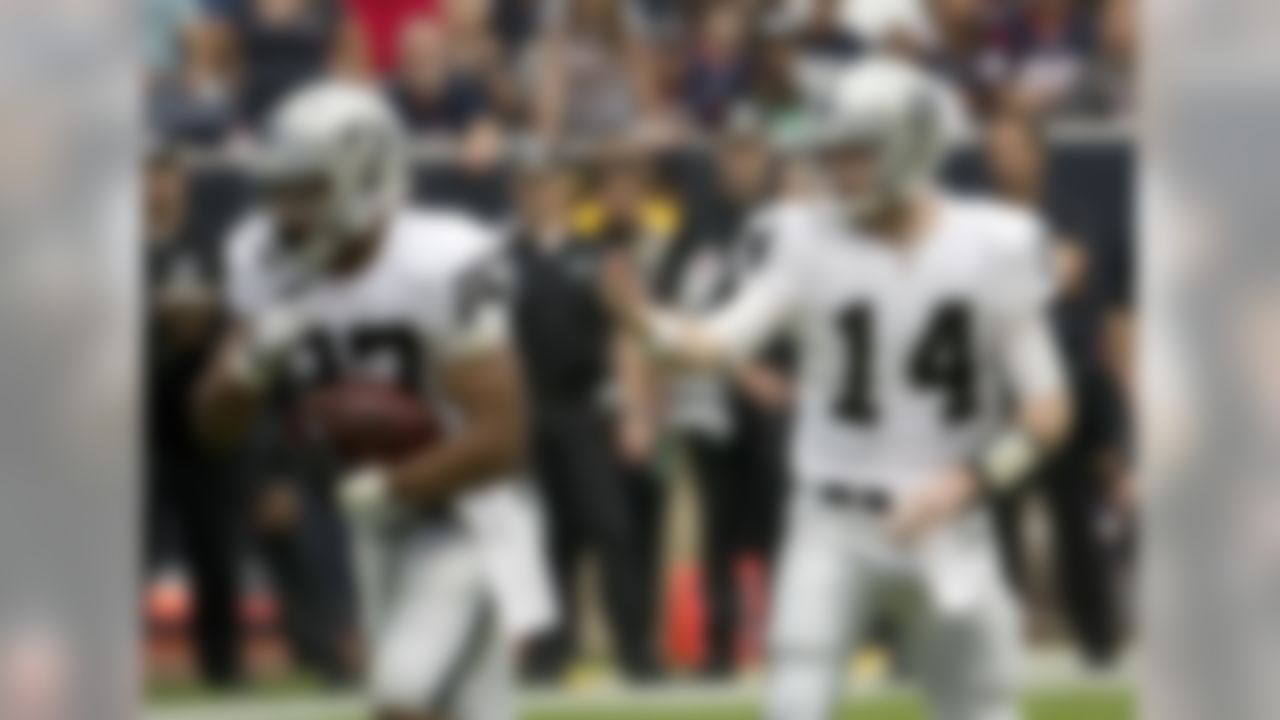 Oakland Raiders' Matthew McGloin hands off to Taiwan Jones (22) during the first half of an NFL football game against the Houston Texans Sunday, Nov. 17, 2013, in Houston. (AP Photo/Morry Gash)