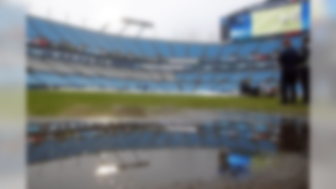 Workers remove a rain cover from the playing field prior to an NFL football game between the Carolina Panthers and the Washington Redskins in Charlotte, N.C., Sunday, Dec. 1, 2019. (AP Photo/Brian Blanco)