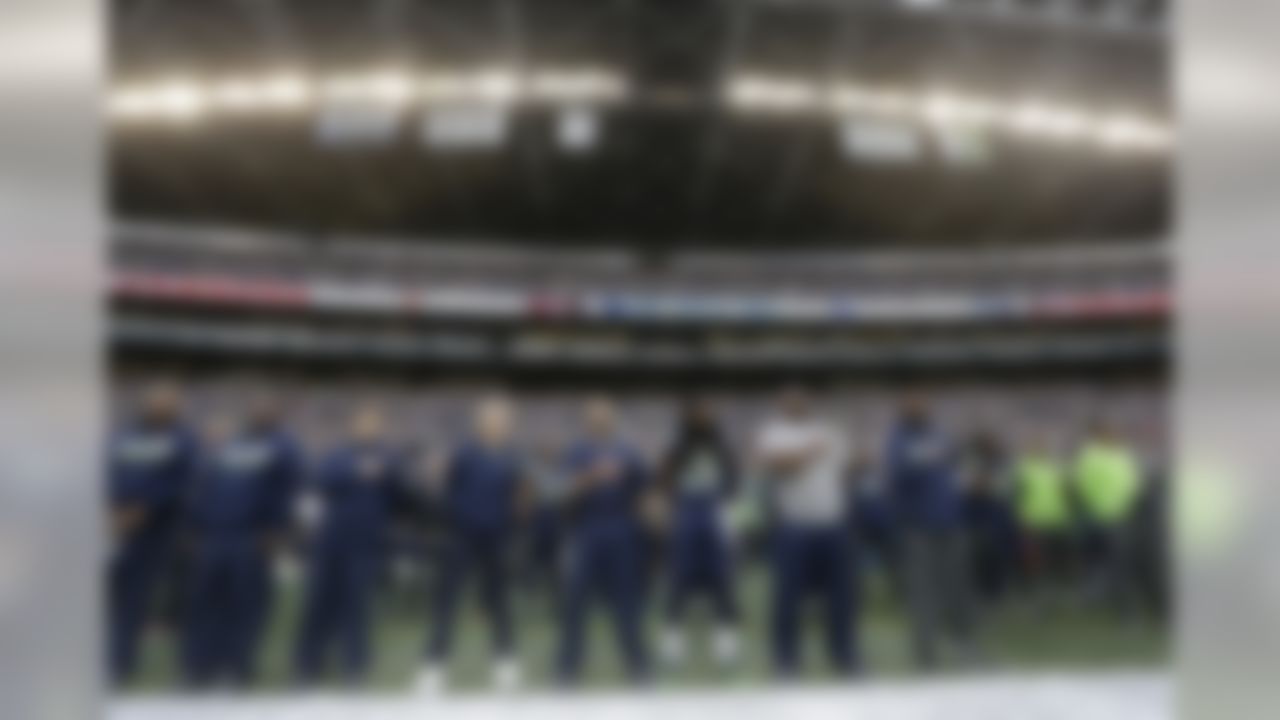 Seattle Seahawks players and coaches, including head coach Pete Carroll fourth from left, and cornerback Richard Sherman (25) stand during the singing of the national anthem before an NFL football game against the Indianapolis Colts, Sunday, Oct. 1, 2017, in Seattle. (AP Photo/Elaine Thompson)