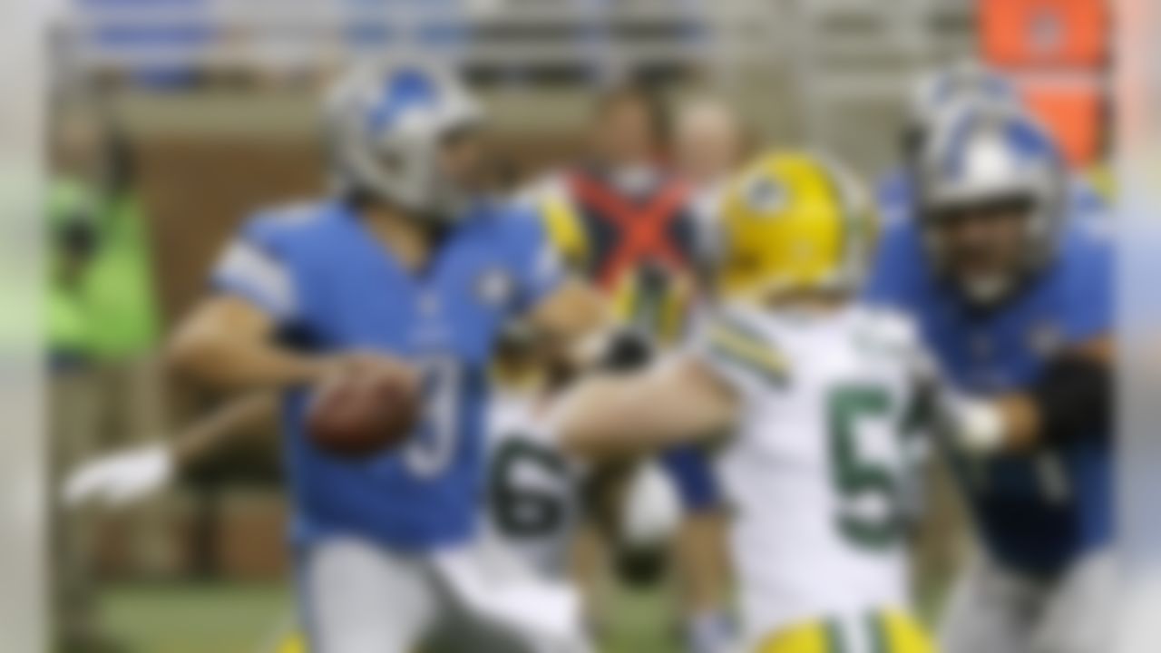 Detroit Lions quarterback Matthew Stafford, under pressure from Green Bay Packers inside linebacker A.J. Hawk, looks downfield during the first half of an NFL football game in Detroit, Sunday, Sept. 21, 2014. (AP Photo/Carlos Osorio)