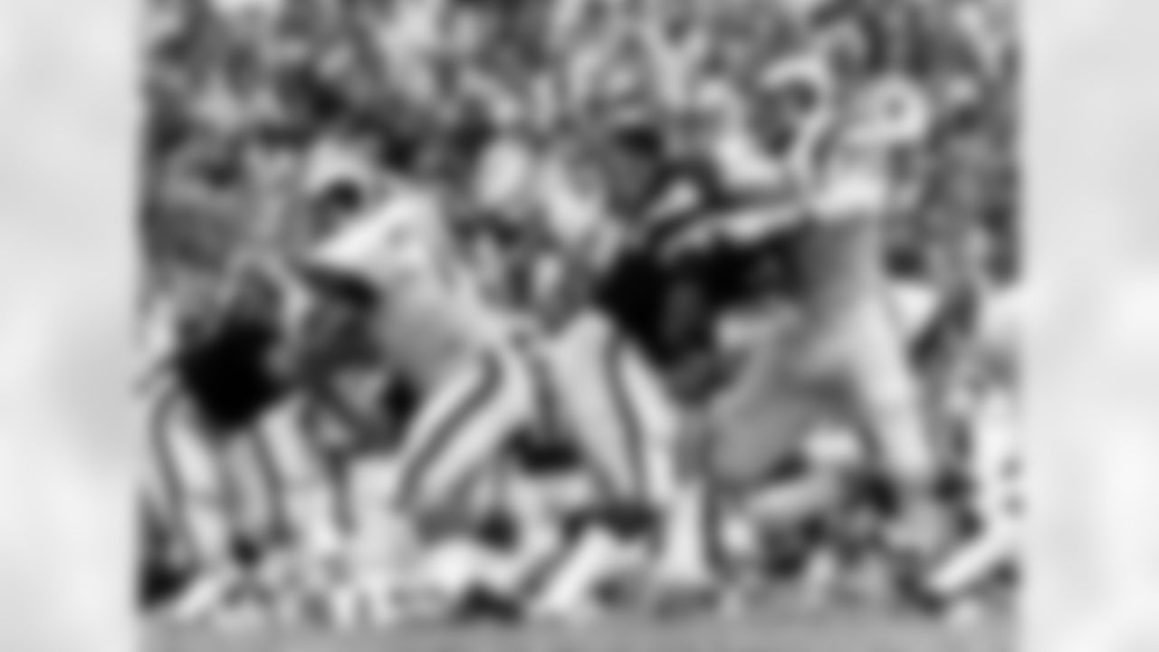 Hall of Fame defensive tackle Merlin Olsen (74) of the Los Angeles Rams has his sights on the quarterback as Hall of Fame defensive end Deacon Jones (75) of the Los Angeles Rams battles Raiders Hall of Fame tackle Bob Brown (76). (National Football League)