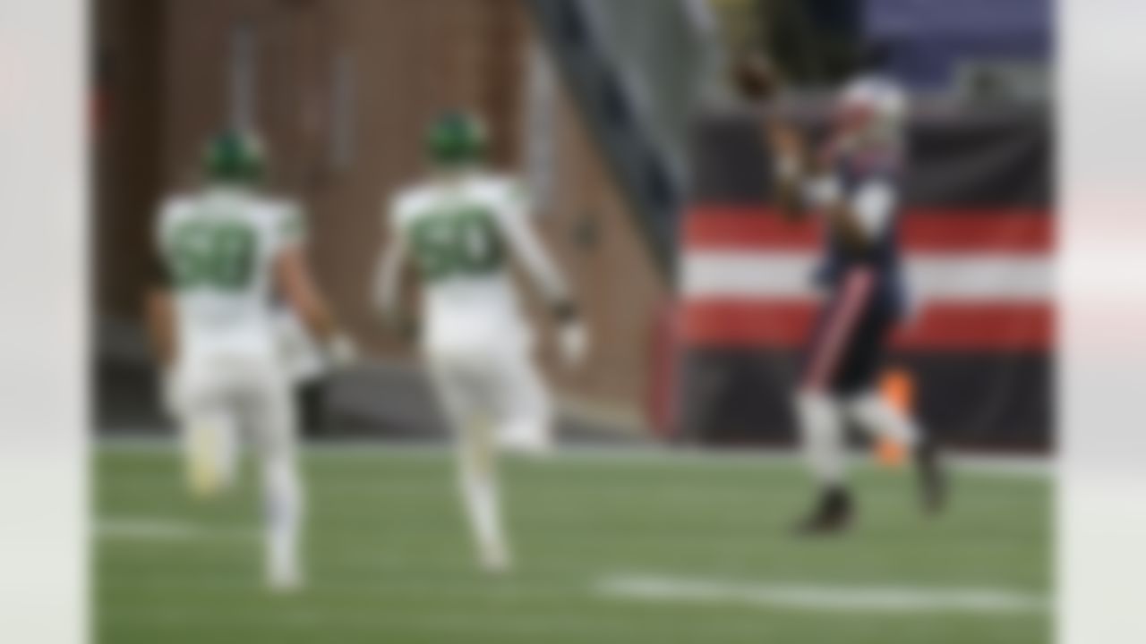 New England Patriots quarterback Cam Newton, right, catches a touchdown pass thrown by wide receiver Jakobi Meyers, as New York Jets defenders Bryce Hager, left, and Frankie Luvu give chase in the second half of an NFL football game, Sunday, Jan. 3, 2021, in Foxborough, Mass.