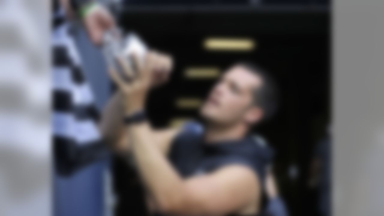 Oakland Raiders quarterback Derek Carr gives autographs before an NFL football preseason game against the Seattle Seahawks, Thursday, Aug. 30, 2018, in Seattle. (AP Photo/Stephen Brashear)