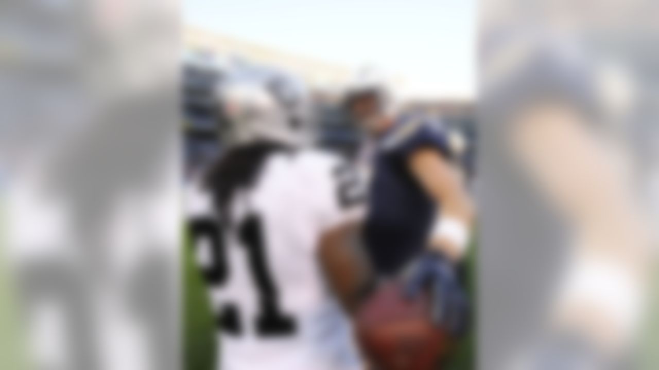 San Diego Chargers quarterback Philip Rivers, right, talks with Oakland Raiders cornerback Mike Jenkins (21) after of an NFL football game Sunday, Dec. 22, 2013, in San Diego. The Chargers won 26-13. (AP Photo/Denis Poroy)