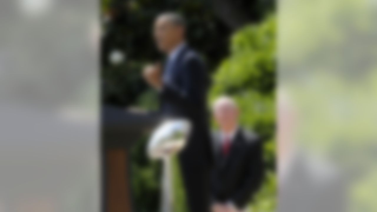 With the Super Bowl trophy in the foreground, and New York football Giants head coach Tom Coughlin in the background,  President Barack Obama speaks on the South Lawn at the White House in Washington, Friday, June 8, 2012, during a ceremony honoring the Super Bowl XLVI Champions. (AP Photo/Susan Walsh)