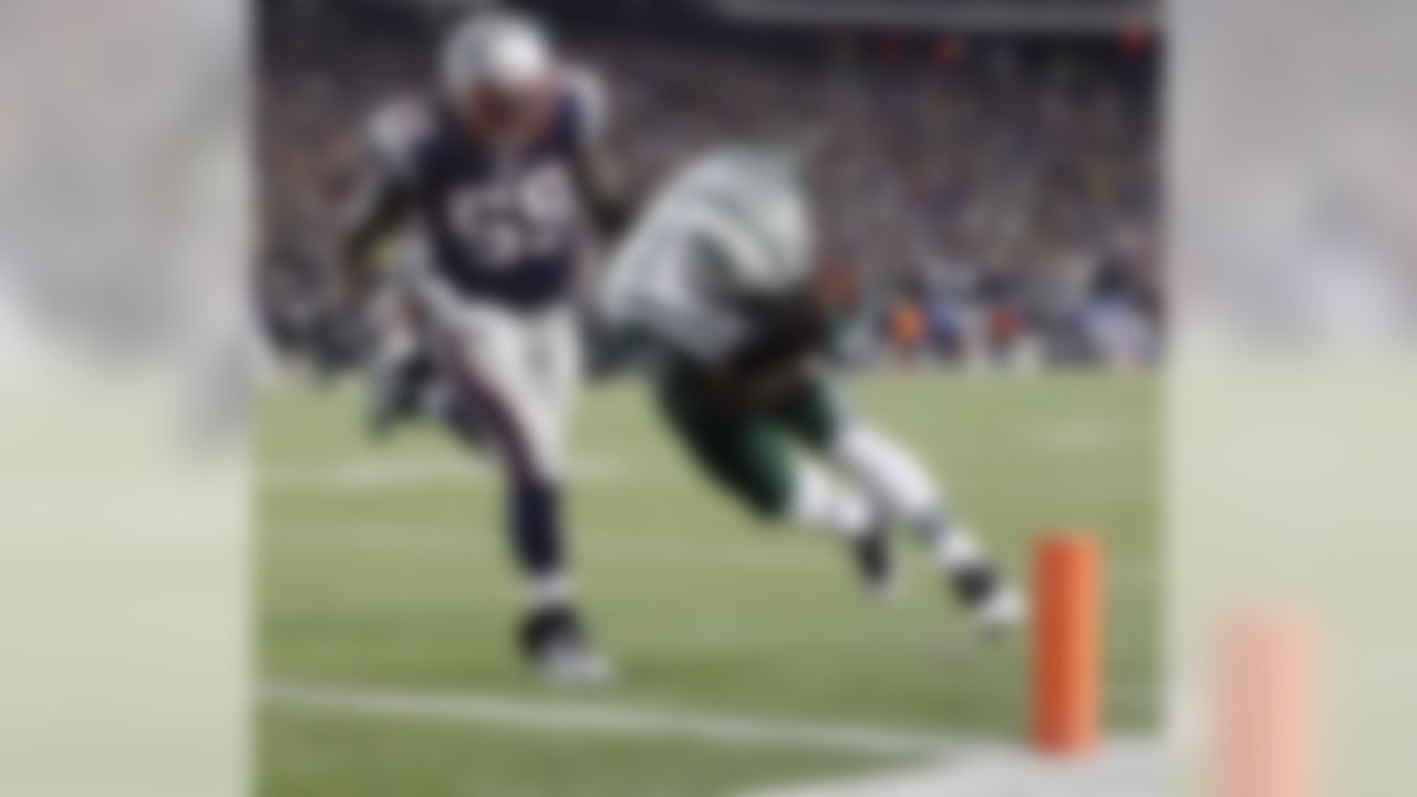 New York Jets running back LaDainian Tomlinson (21) scores a touchdown in front of New England Patriots linebacker Gary Guyton (59) during the first half of an NFL divisional playoff football game in Foxborough, Mass., Sunday, Jan. 16, 2011. (AP Photo/Winslow Townson)