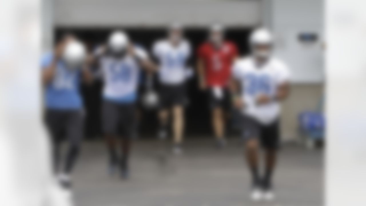 Detroit Lions free agents, from left, Rashied Davis, Ashlee Palmer, Bobby Carpenter, Drew Stanton and Paul Pratt run onto the field to start drills at the NFL football team's training camp in Allen Park, Mich., Thursday, Aug. 4, 2011. (AP Photo/Carlos Osorio)