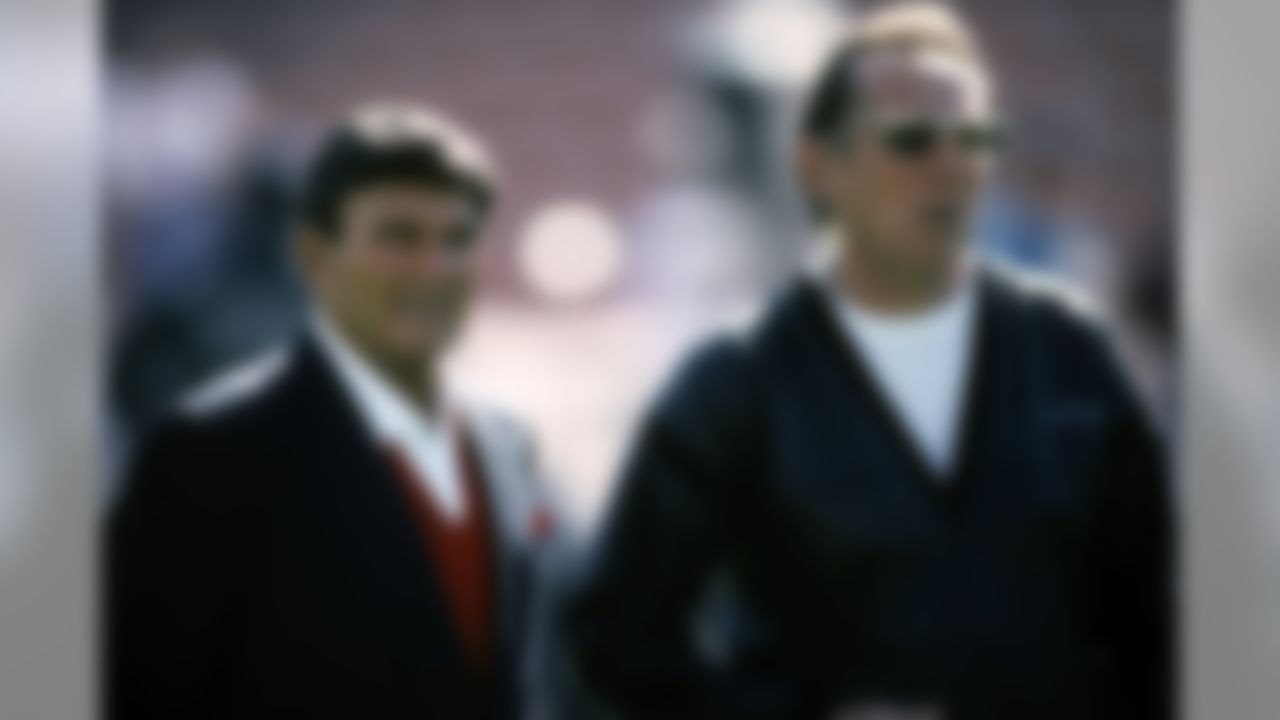 Old foes talk on the field as Kansas City Chiefs Hall of Fame head coach Hank Stram, working as the CBS Radio analyst, and Los Angeles Raiders Managing General Partner Al Davis get together before the Raiders 20-10 victory over the Cincinnati Bengals in the 1990 AFC Divisional Playoff Game on January 13, 1991 at the Los Angeles Memorial Coliseum in Los Angeles, California. (National Football League)
