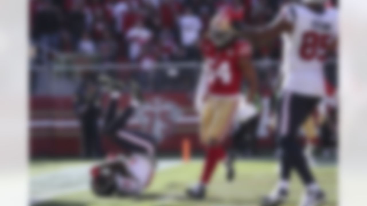 Houston Texans wide receiver Brandin Cooks (13) rolls backward in the end zone after scoring a touchdown next to San Francisco 49ers middle linebacker Fred Warner (54) during the first half of an NFL football game in Santa Clara, Calif., Sunday, Jan. 2, 2022.