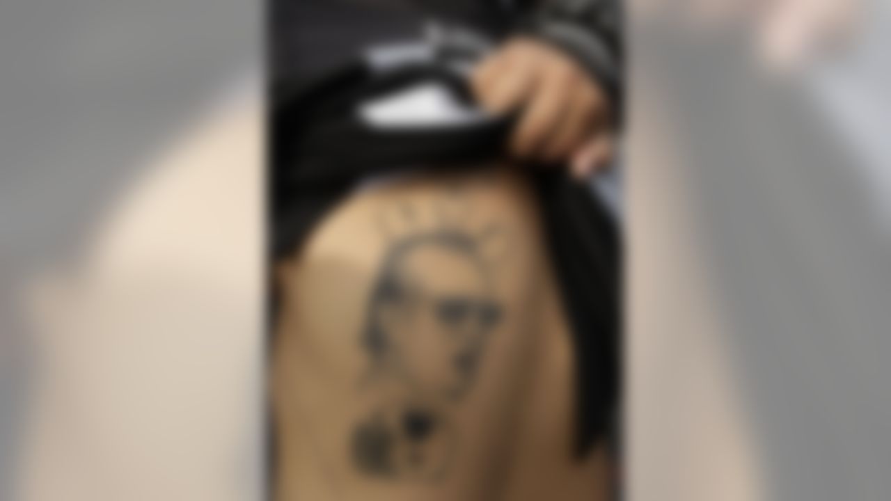 A Raiders fan shows off a tattoo with an image of former owner Al Davis before an NFL football game against the Chicago Bears in Oakland, Calif., Sunday, Nov. 27, 2011. (AP Photo/Paul Sakuma)