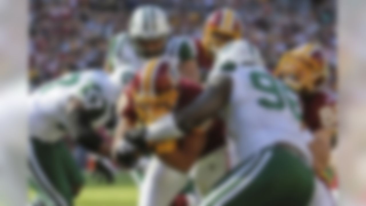 Washington Redskins running back Roy Helu, center, runs between New York Jets inside linebacker Bart Scott, left, and defensive end Muhammad Wilkerson, right, to score a touchdown during the first half of an NFL football game in Landover, Md., Sunday, Dec. 4, 2011. (AP Photo/Nick Wass)