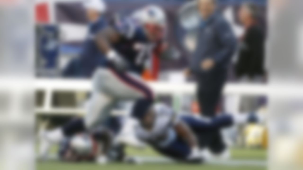 New England Patriots nose tackle Vince Wilfork (75) runs over cornerback Devin McCourty (32) with the football after intercepting a pass as San Diego Chargers running back Mike Tolbert (35) reaches out to bring him down in the second quarter of an NFL fooball game Foxborough, Mass., Sunday, Sept. 18, 2011. (AP Photo/Charles Krupa)