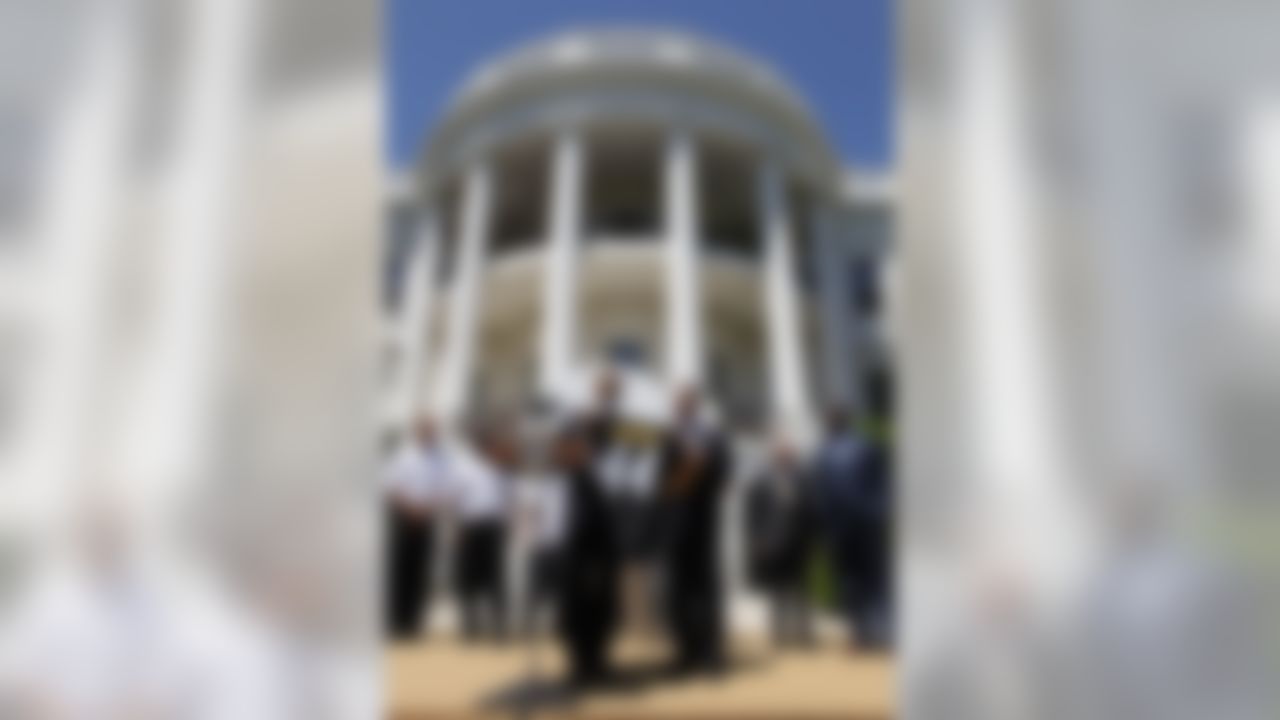 President Barack Obama is presented with a team jersey by Pittsburgh Steelers President Arthur J. Rooney II as team Chairman Dan Rooney, second from right, and coach Mike Tomlin, look on as the president honored the Super Bowl champion Pittsburgh Steelers, Thursday, May 21, 2009, on the South Lawn of the White House in Washington. Dan Rooney has been nominated to become U.S. Ambassador to Ireland. (AP Photo/Charles Dharapak)