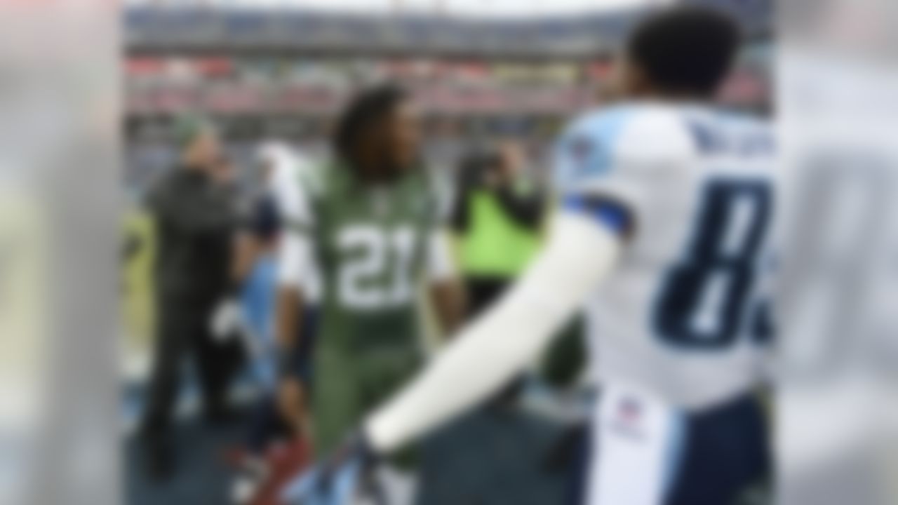 New York Jets running back Chris Johnson (21) talks with Tennessee Titans wide receiver Nate Washington (85) before an NFL football game Sunday, Dec. 14, 2014, in Nashville, Tenn. Johnson is facing his former Titans teammates for the first time Sunday. (AP Photo/Mark Zaleski)