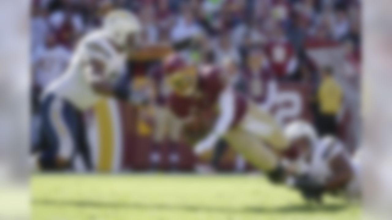 Washington Redskins quarterback Robert Griffin III is stopped by San Diego Chargers defensive end Kendall Reyes, left, and outside linebacker Larry English, right, during the first half of a NFL football game in Landover, Md., Sunday, Nov. 3, 2013. (AP Photo/Alex Brandon)