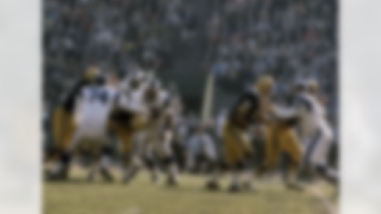 Los Angeles Rams defensive end Lamar Lundy (85) and Hall of Fame defensive tackle Merlin Olsen (74) drop Green Bay Packers Hall of Fame quarterback Bart Starr (15) for a loss during a 27-24 Rams victory on December 9, 1967, at the Los Angeles Memorial Coliseum. (National Football League)