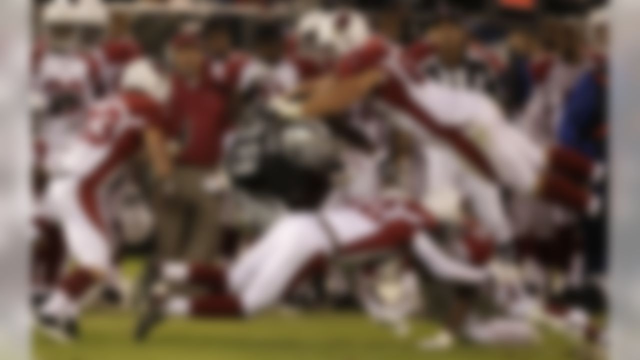 Oakland Raiders tight end Kevin Brock (88) is tackled in between Arizona Cardinals safety Tommy Irvin (33), defensive lineman Jeremy Navarre (69), safety Jared Campbell (32), and linebacker Quan Sturdivant (54) in the second half of an NFL preseason football game in Oakland, Calif., Thursday, Aug. 11, 2011. (AP Photo/Ben Margot)