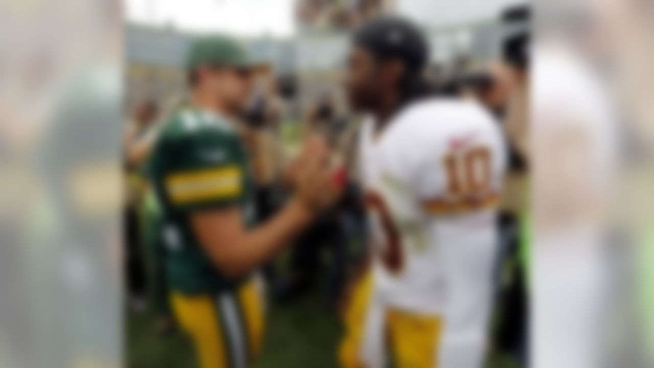 Green Bay Packers quarterback Aaron Rodgers (12) talks to Washington Redskins quarterback Robert Griffin III after an NFL football game Sunday, Sept. 15, 2013, in Green Bay, Wis. The Packers won 38-20. (AP Photo/Mike Roemer)