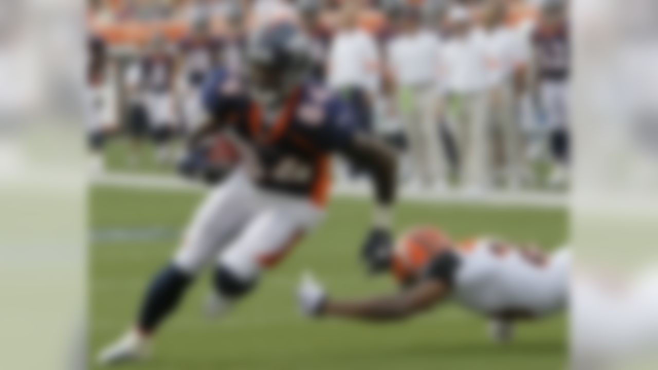 Denver Broncos receiver Brandon Lloyd (84) avoids a tackle by Cincinnati Bengals cornerback Leon Hall (29) for a 6-yard touchdown reception in the first half of an NFL preseason football game, Sunday, Aug. 15, 2010, in Cincinnati. (AP Photo/Ed Reinke)