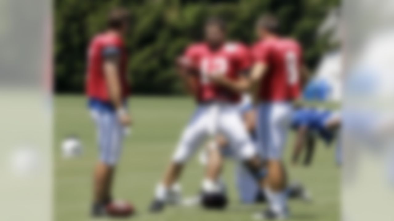 Indianapolis Colts quarterback Andrew Luck, center, talks with fellow quarterbacks Drew Stanton, left, and Chandler Harnish during the NFL team's football training camp in Anderson, Ind., Monday, Aug. 6, 2012.  (AP Photo/Michael Conroy)